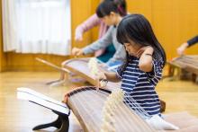 創作体験をする子供3　琴を弾くこども