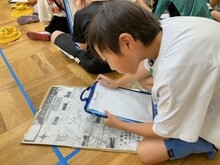 マップを見ながらレポートを書くこどもたち