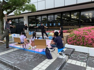 野外で椅子に座りながら催しを楽しむ利用者