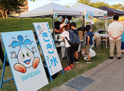 きき水コーナーの看板と、参加する人々の写真