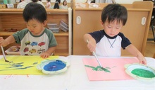 筆で描くことに挑戦するこどもたちの写真