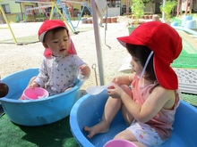 タライに張った水につかるこどもたちの写真