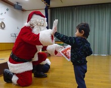 サンタにハイタッチするこども