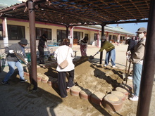 砂場に砂を入れている写真