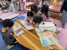 友だちと一緒に絵本を読んでいる写真