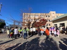 桜の木の前でうたを歌っている写真