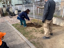 園長先生が土を入れている写真