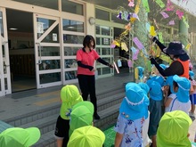 小学校の先生に笹飾りを渡している写真