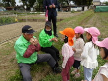 地域の人に草笛を教えてもらっている写真