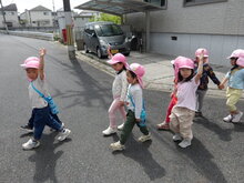 手をあげて道を渡っている写真