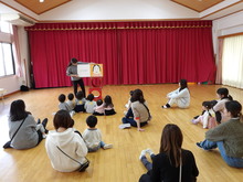 座って絵本を見ている写真