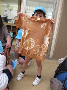 仕上がったTシャツを広げるこどもの写真