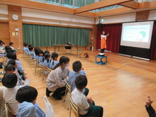 スライドの資料に注目するこどもたちの写真