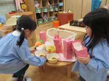 屋内でごっこ遊びをするこどもたちの写真