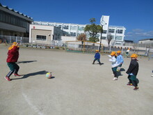 屋外でボールをけろうとしているこどもたち