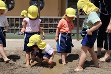 こどもたちが泥んこ遊びをしている写真