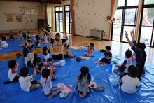 シートの上に集まって座っているこどもたちの写真