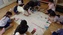 大きな模造紙に地図を描くこどもたちの写真