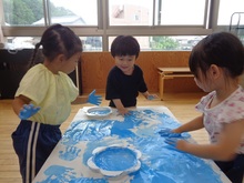 絵の具で模造紙いっぱいにぬたくり遊びをしています