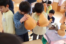 瓢箪の穴をのぞき込む子供たち
