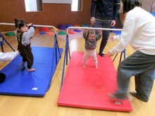 鉄棒に手をのばすこどもたちの写真