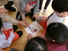 大型かるたをしている途中、誰が早かったか話し合いをしています。