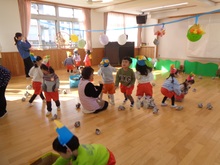 節分ごっこで、新聞紙を使って的に当てたり入れたりしています。