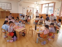 遊戯室で特別の給食です。職員室の先生も一緒に食べている所です。