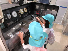 運転席のコーナーで体験するこどもたち