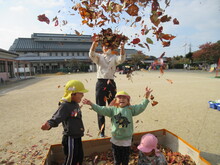 落ち葉を撒いて遊ぶこどもたち