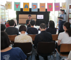 バトラーが聴衆の前で発表をしている写真