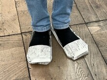 簡易の避難用靴作りを足に履くこどもの写真