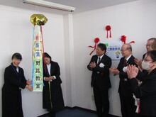 やまびこ野路教室開室　くす玉が開き、関係者が拍手をしているようす