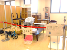 リユース品が「出品中」の札とともに並べられているようす