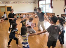 こどもが手をつないで輪を作っている写真