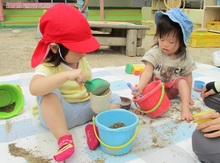 シートを敷いて砂遊びをしている写真