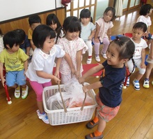 食材が入ったカゴを持って重さを感じている写真