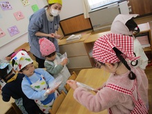 机の上で袋をもつこどもたち