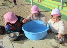 タライにできた丸い氷を持っている写真