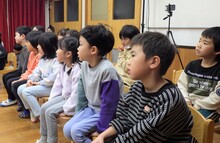 ジンケンジャー劇を見るこどたちの写真