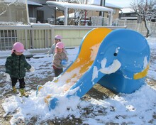 すべり台で雪玉を転がす様子