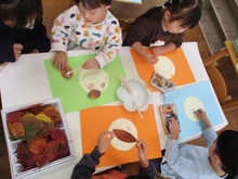 落ち葉を使って顔を作っているところ