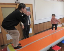 1歳児がトランポリンをしている写真