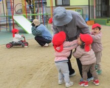 保育者と追いかけっこをしている写真