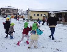 雪が積もった園庭を走るこどもたちのようす