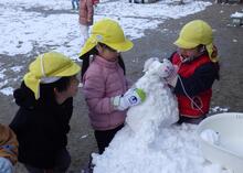 雪を集めて雪だるまを作っているようす