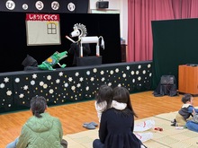 舞台上の人形劇を鑑賞するこどもたちの写真1