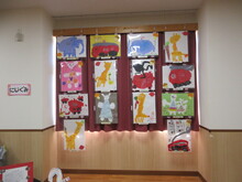 カーテン前に吊り下げられた絵画作品の写真