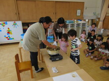 鍋に注目するこどもたちの写真