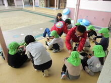 苗を植え手に持つこどもたちの写真